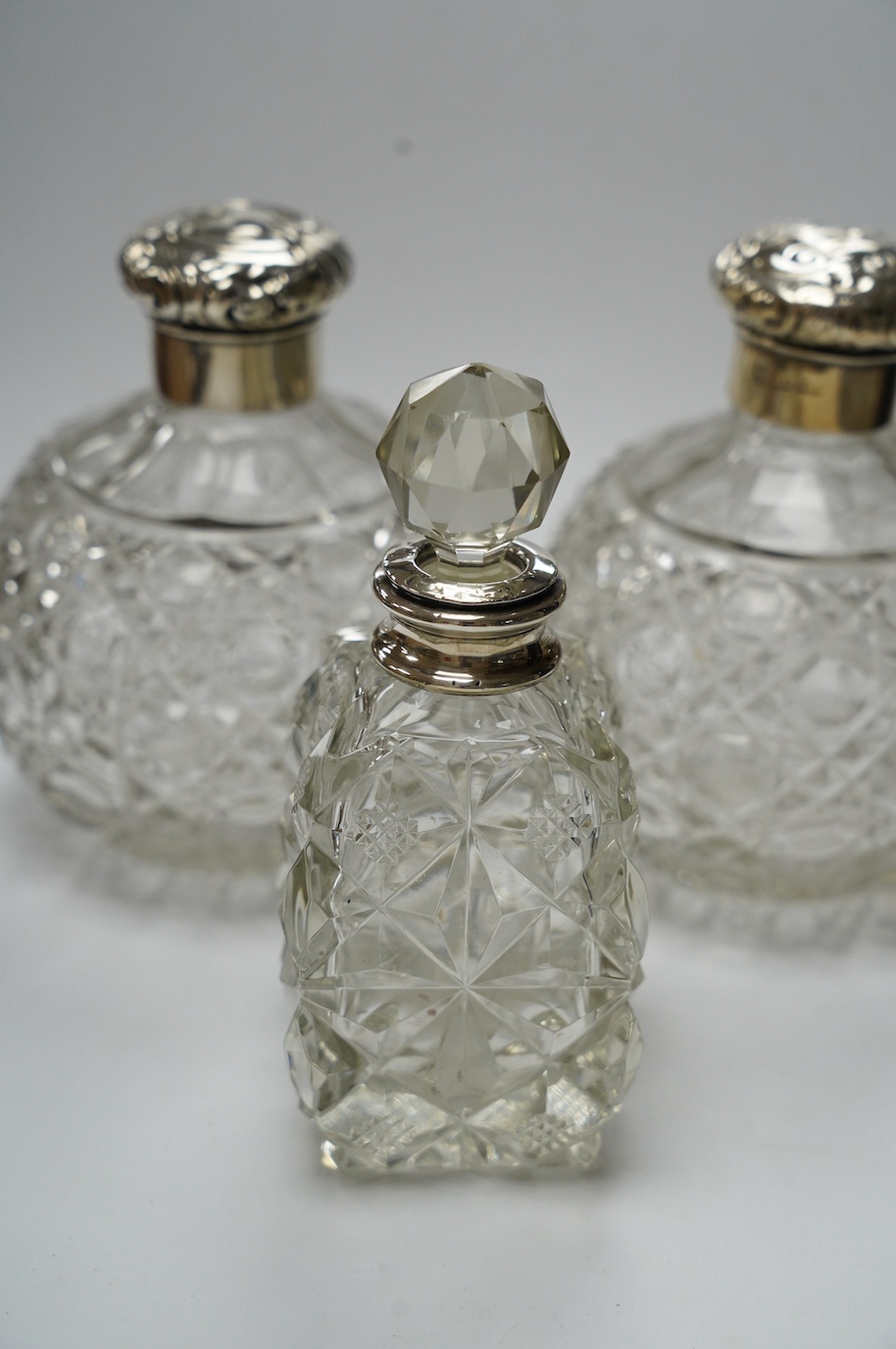 A pair of silver mounted cut glass scent bottles, marks rubbed, 12.3cm and one other silver mounted scent bottle. Condition - poor